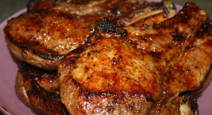 Сочные острые стейки рибай на мангале на решетке.