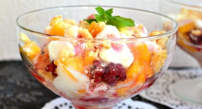 Десерт из мороженого с персиками и малиной