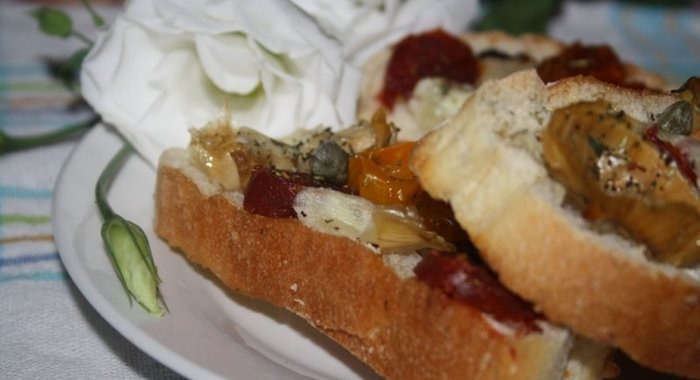 Кростини с печеными артишоками, чоризо, каперсами и молодым овечьим сыром