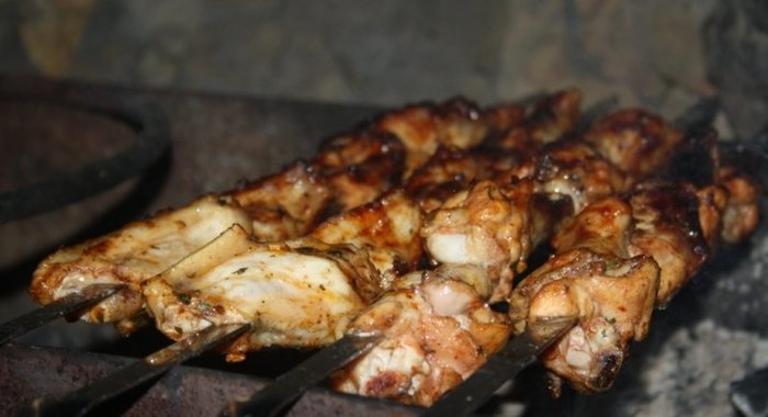 Куриные крылышки на шампурах на мангале в томатном маринаде