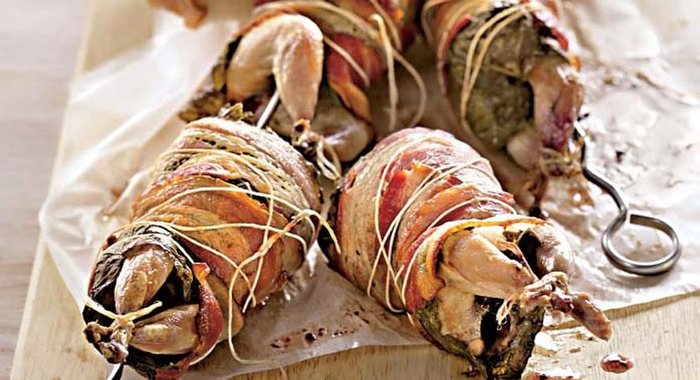 Перепела на вертеле в беконе и виноградных листьях