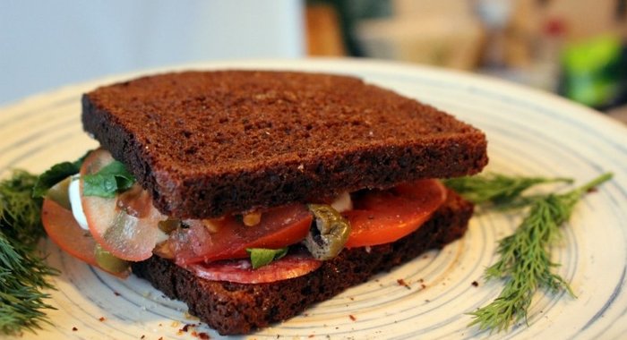 Сендвич из ржаного хлеба с салями и помидором