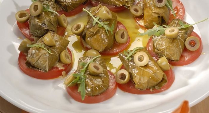 Козий сыр в виноградных листьях с томатами и оливками